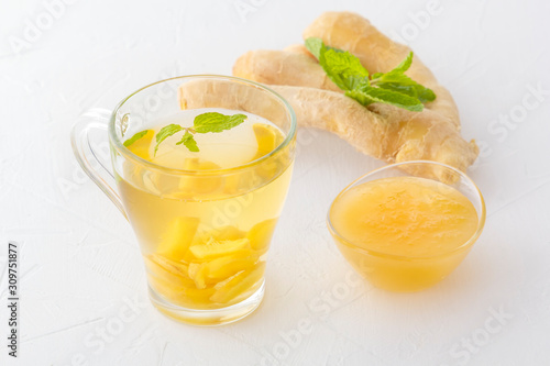 Ginger tea with honey and mint on a white wooden table. Close-up