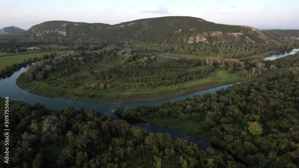 The remain of the reef of the ancient sea, composed of limestone - shikhan Kushtau on a summer day. The main river of Bashkiria - Belaya. Aerial view. The remain of the reef of the ancient sea, composed of limestone - shikhan Kushtau on a summer day. The main river of Bashkiria - Belaya. Aerial view.