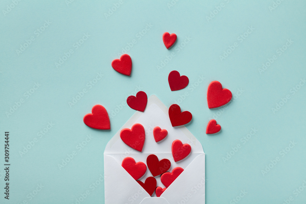 Valentine day greeting concept. Envelope and red hearts on blue background top view. Flat lay. - obrazy, fototapety, plakaty 