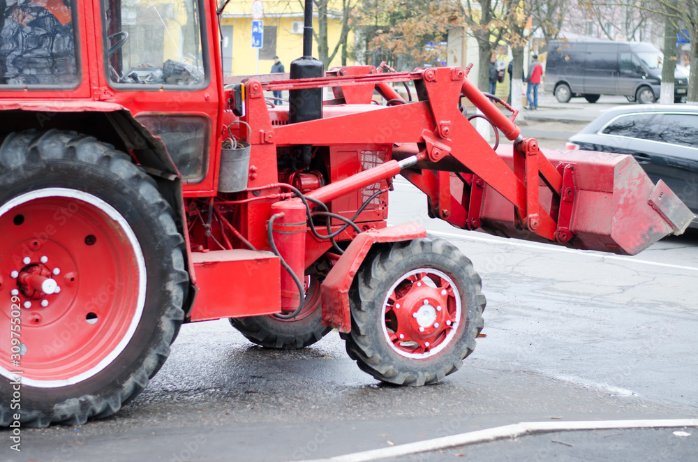 Izmail, Ukraine - December 13, 2019: Red tractor of city public utilities rides on an emergency call Izmail, Ukraine - December 13, 2019: Red tractor of city public utilities rides on an emergency call