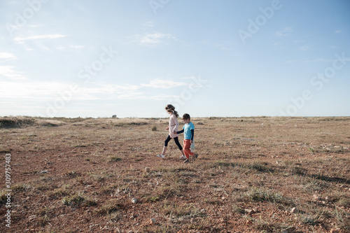 Valokuva two little children orphan migrant refugees boy with toy and girl walking along