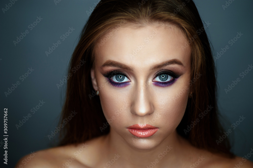 Portrait of a young woman with beautiful evening make-up on a dark background Portrait of a young woman with beautiful evening make-up on a dark background