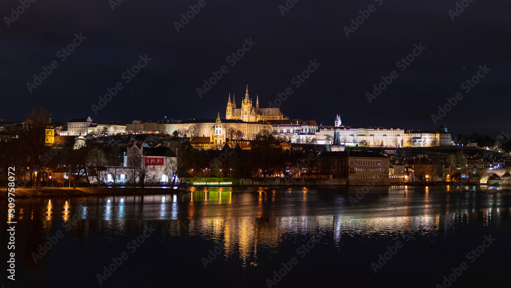 Castle of Prague cityscape at night with the lake and bridge in the front