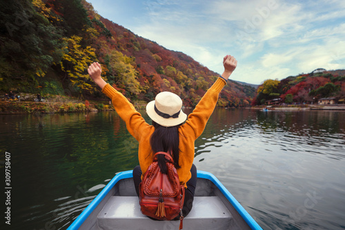 Photography Asian girl relax by paddle and a rent boat on river in arashiyama park