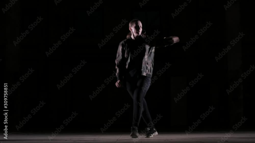 Young beautiful girl dancing hip hop, street dancing in the studio on black background, isolated Young beautiful girl dancing hip hop, street dancing in the studio on black background, isolated