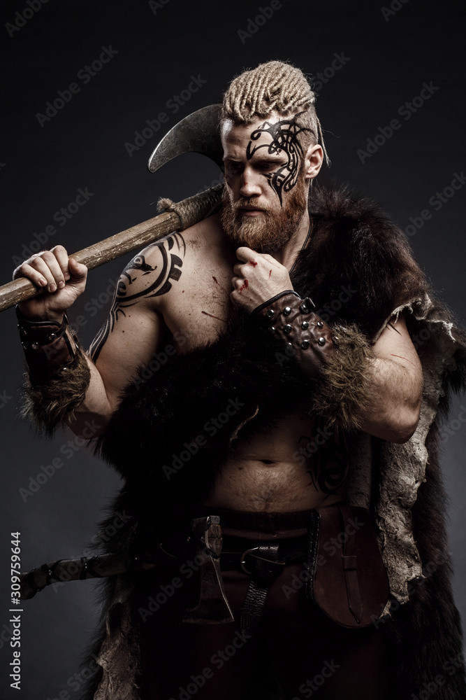 Medieval warrior berserk Viking with tattoo with axes attacks enemy ...