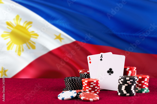 Philippines casino theme. Aces in poker game, cards and chips on red table with national flag background. Gambling and betting. photo