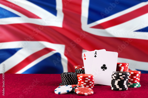 United Kingdom casino theme. Aces in poker game, cards and chips on red table with national flag background. Gambling and betting. photo