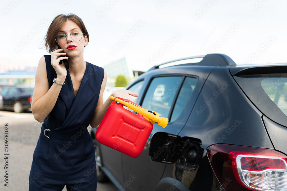 Beutiful woman in strict style of clothing gets out of the car for an important meeting in the office but her car ran out of gas Beutiful woman in strict style of clothing gets out of the car for an important meeting in the office but her car ran out of gas