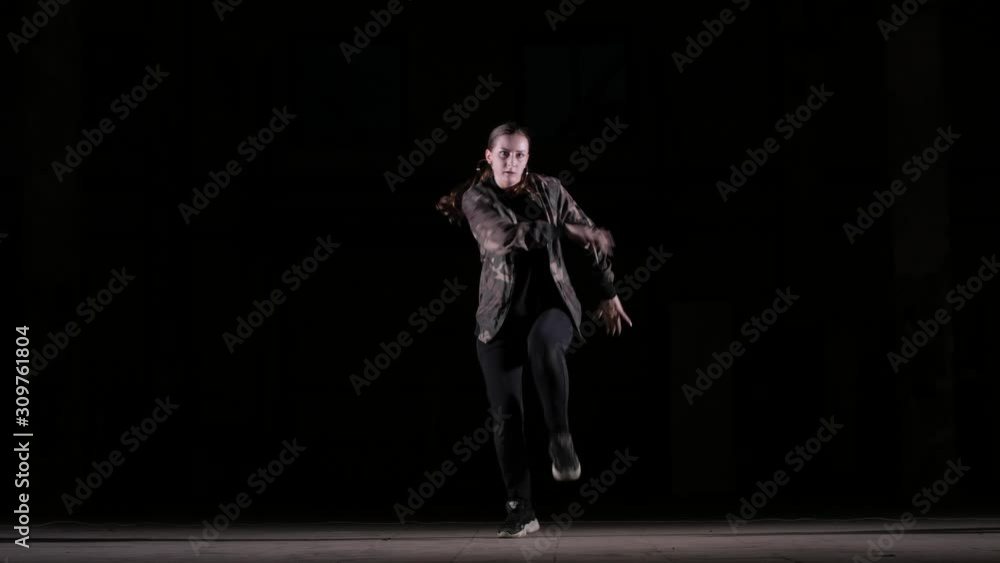 Young beautiful girl dancing hip hop, street dancing in the studio on black background, isolated Young beautiful girl dancing hip hop, street dancing in the studio on black background, isolated