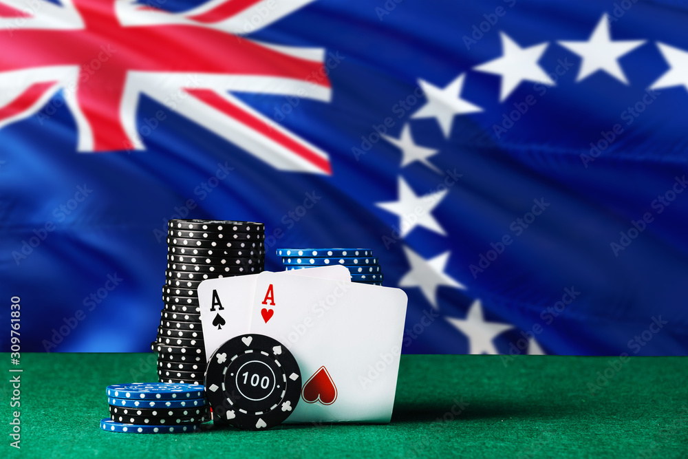 Obraz premium Cook Islands casino theme. Two ace in poker game, cards and black chips on green table with national flag background. Gambling and betting.