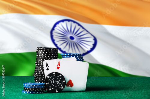 India casino theme. Two ace in poker game, cards and black chips on green table with national flag background. Gambling and betting. photo