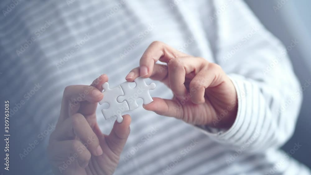 piece of jigsaw connecting together by hand, step of success concept piece of jigsaw connecting together by hand, step of success concept