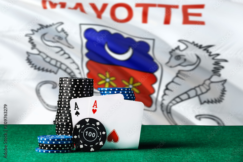 Mayotte casino theme. Two ace in poker game, cards and black chips on green table with national flag background. Gambling and betting.