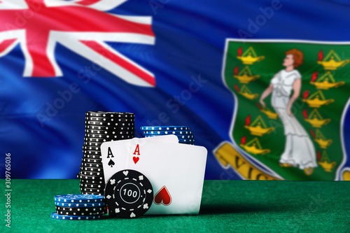 British Virgin Islands casino theme. Two ace in poker game, cards and black chips on green table with national flag background. Gambling and betting. photo