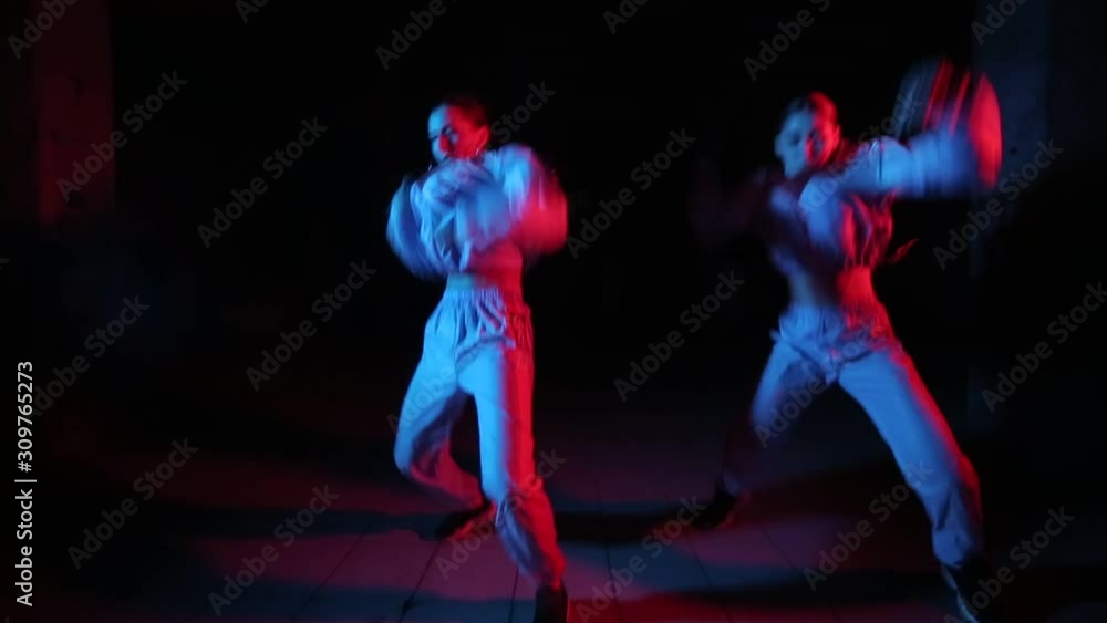 duet of young beautiful girls dancing hip hop, street dancing in the studio on a black background, isolated duet of young beautiful girls dancing hip hop, street dancing in the studio on a black background, isolated