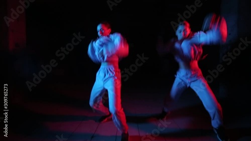 duet of young beautiful girls dancing hip hop, street dancing in the studio on a black background, isolated