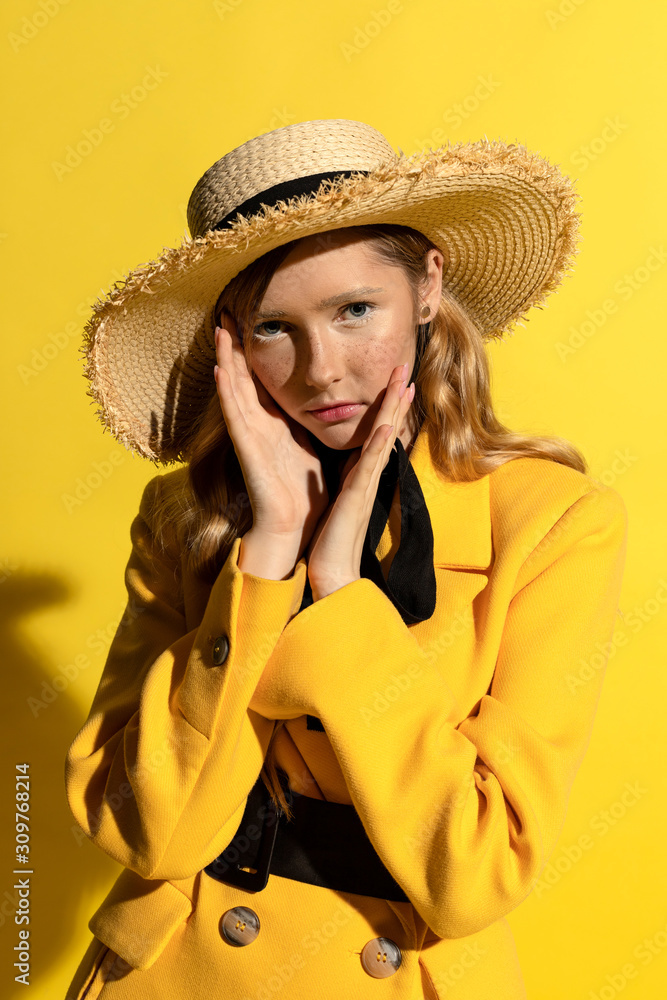 Pretty blonde girl with freckles in yellow outfit and straw hat Pretty blonde girl with freckles in yellow outfit and straw hat
