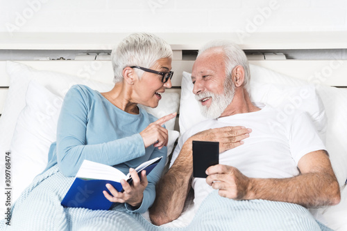 Senior couple reading books at bed