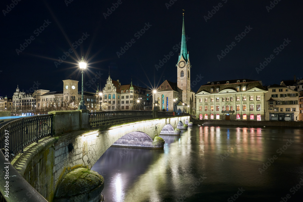 Münsterbrücke und Fraumünster bei Nacht, beleuchtetes Stadthaus und Zunft zur Meisen, Wasserspiegelung in der Limmat