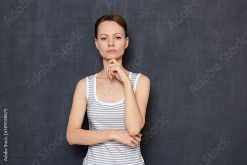 Принти на полотні Portrait of serious focused girl touching chin with hand and thinking