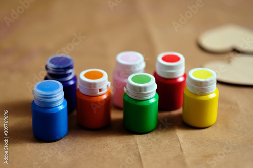 LGBT pride colours acrylic paints near to the clean wooden hearts before colouring