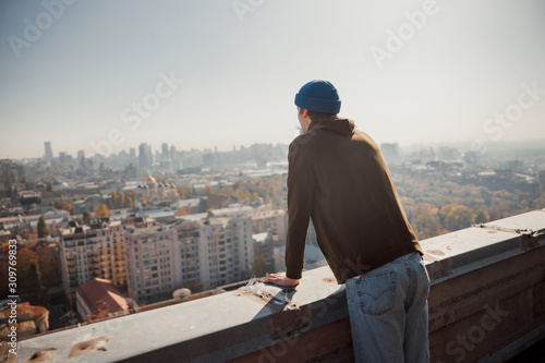 Guy looking at the city view from the roof