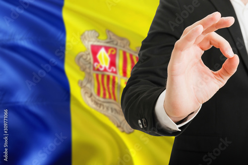 Andorra acceptance concept. Elegant businessman is showing ok sign with hand on national flag background.
