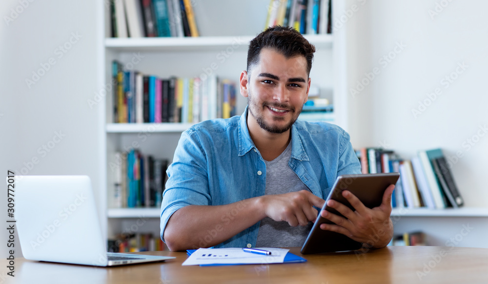 Mexican hipster man reading news with tablet Mexican hipster man reading news with tablet