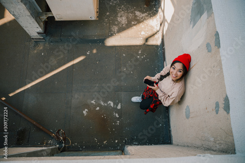Happy young girl in red hat looking up on camera