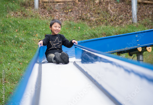 すべり台で遊ぶ小学生の男の子