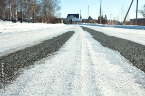 winter asphalt road covered ice crust. snow covered driveway © bakharev