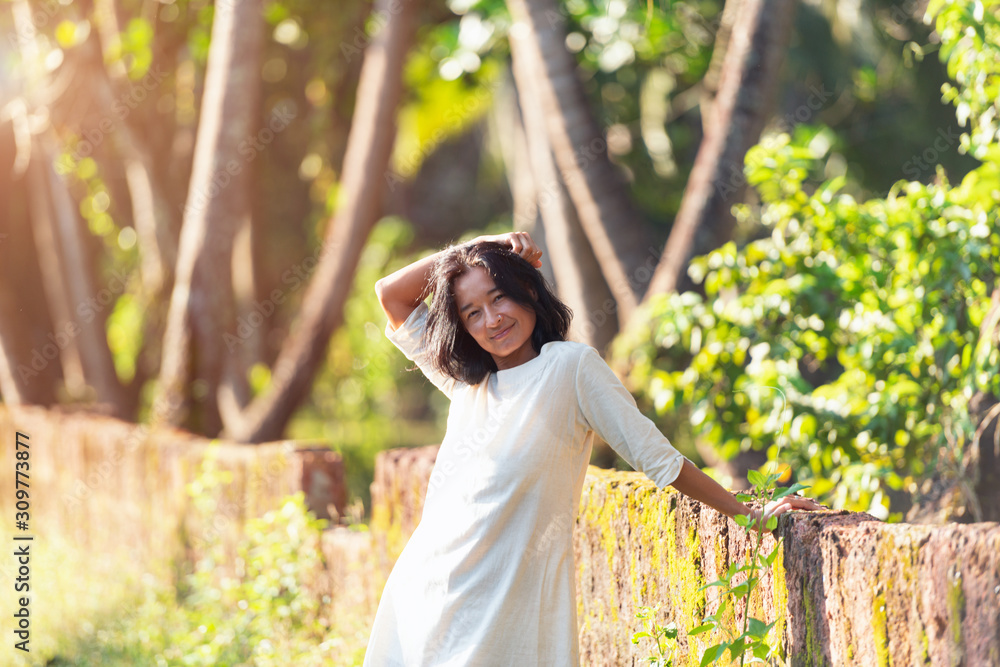 Beautiful and happy asian woman poses at sunrise (sunset) on jungle background on the island of Bali, Indonesia ( india, goa) Beautiful and happy asian woman poses at sunrise (sunset) on jungle background on the island of Bali, Indonesia ( india, goa)
