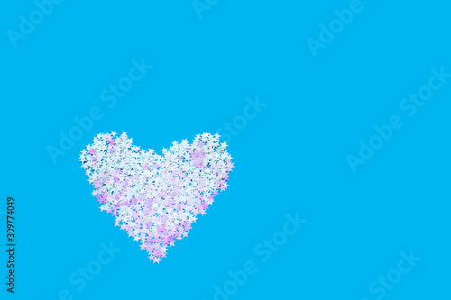 Heart shape of holographic glitter sparkle on blue backdrop. Valentines Day background. Top view, copy space