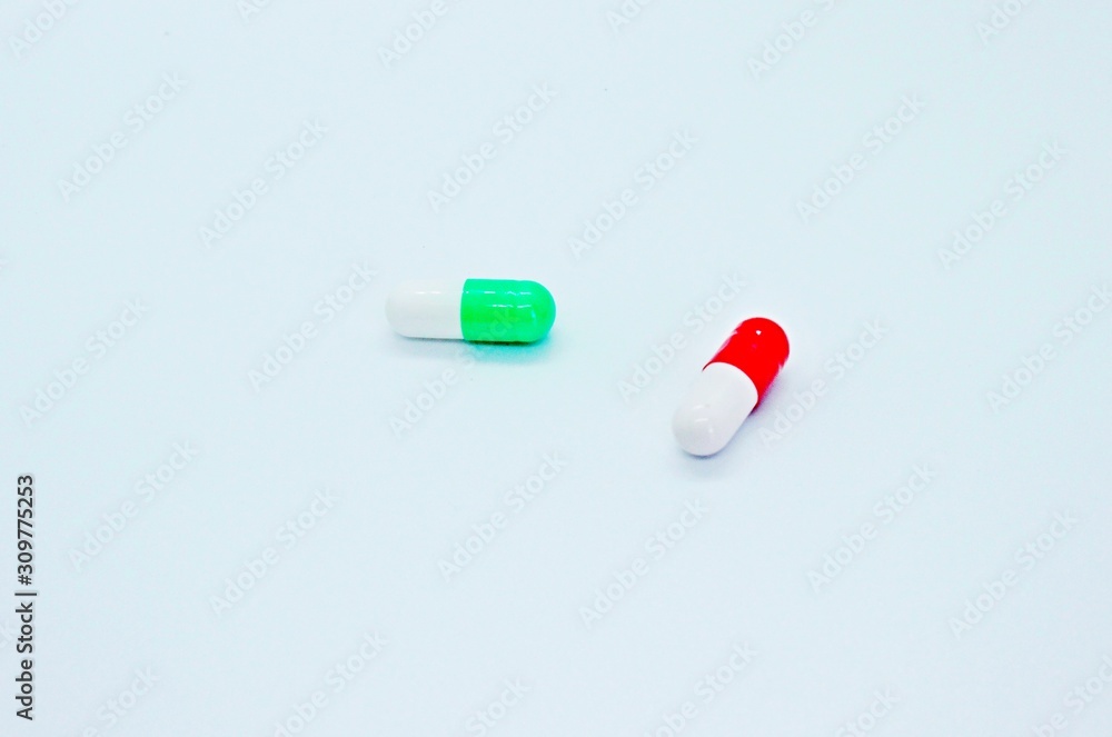 Multi-colored pills are located on a white background Multi-colored pills are located on a white background