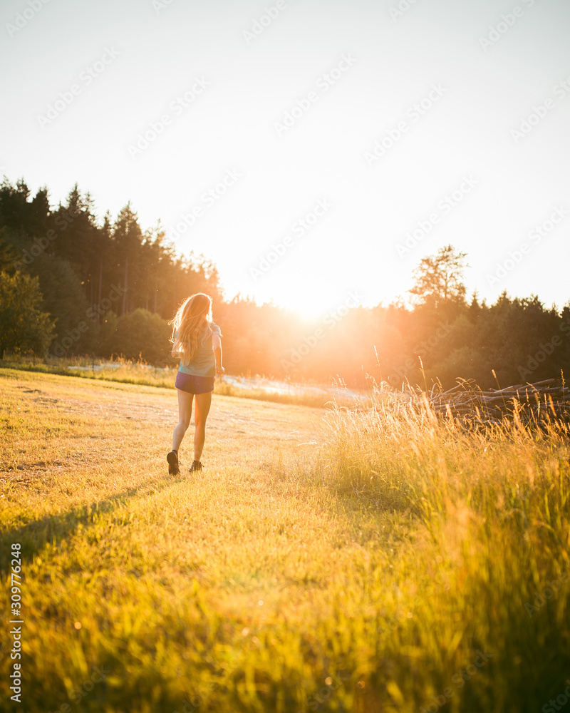 Young Athletic Woman Running in nature during sunset