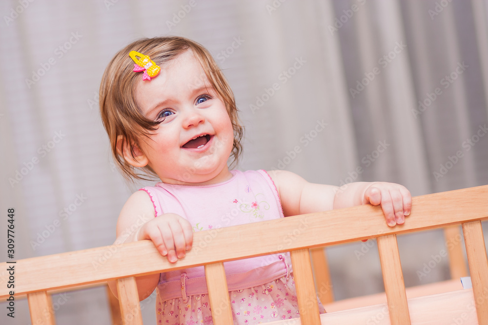 small child with a hairpin standing in crib. small child with a hairpin standing in crib.