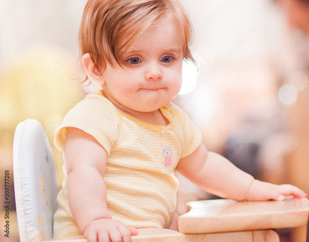 little girl sitting on a wooden chair