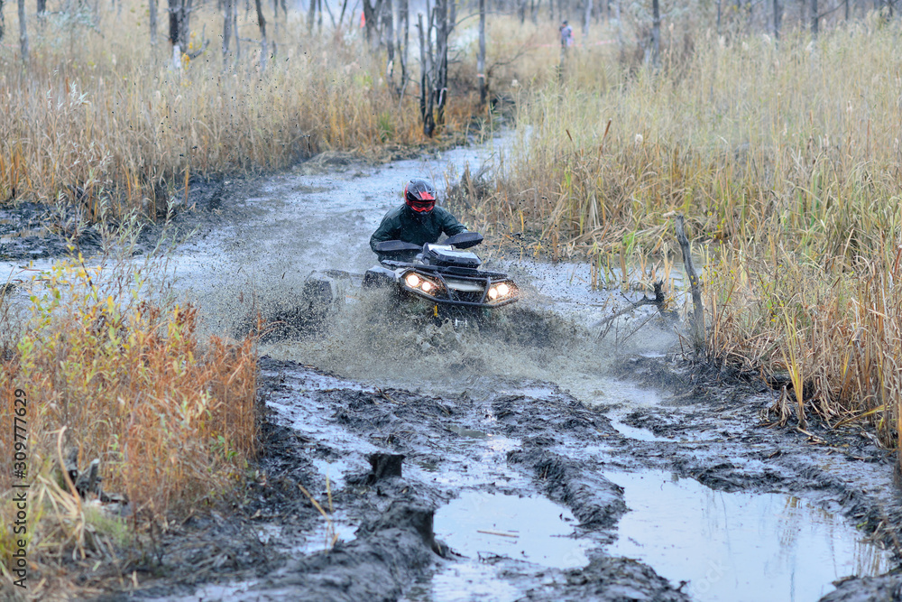 Cool picture of active ATV and UTV driving in mud and water at Autumn