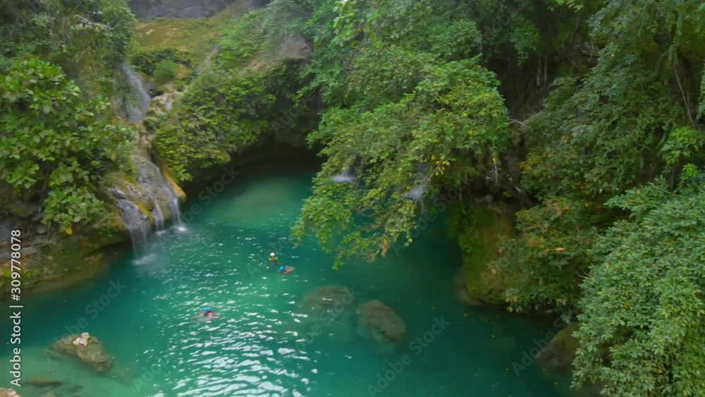 Aerial waterfall landscape in the middle of tropical green jungle at Kawasan Falls in Cebu Island in Philippines. Aerial waterfall landscape in the middle of tropical green jungle at Kawasan Falls in Cebu Island in Philippines.