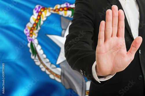 Northern Mariana Islands rejection concept. Elegant businessman is showing stop sign with hand on national flag background.