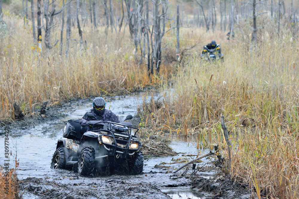 Cool pictures of active ATV driving in mud and water at Autumn weather
