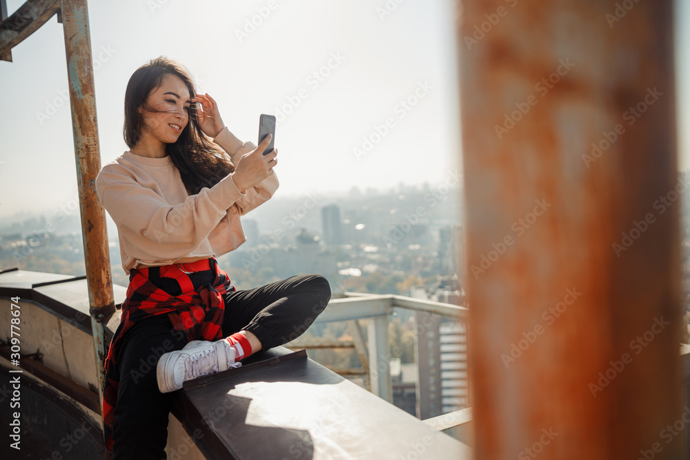 Smiling pretty lady making selfie on roof