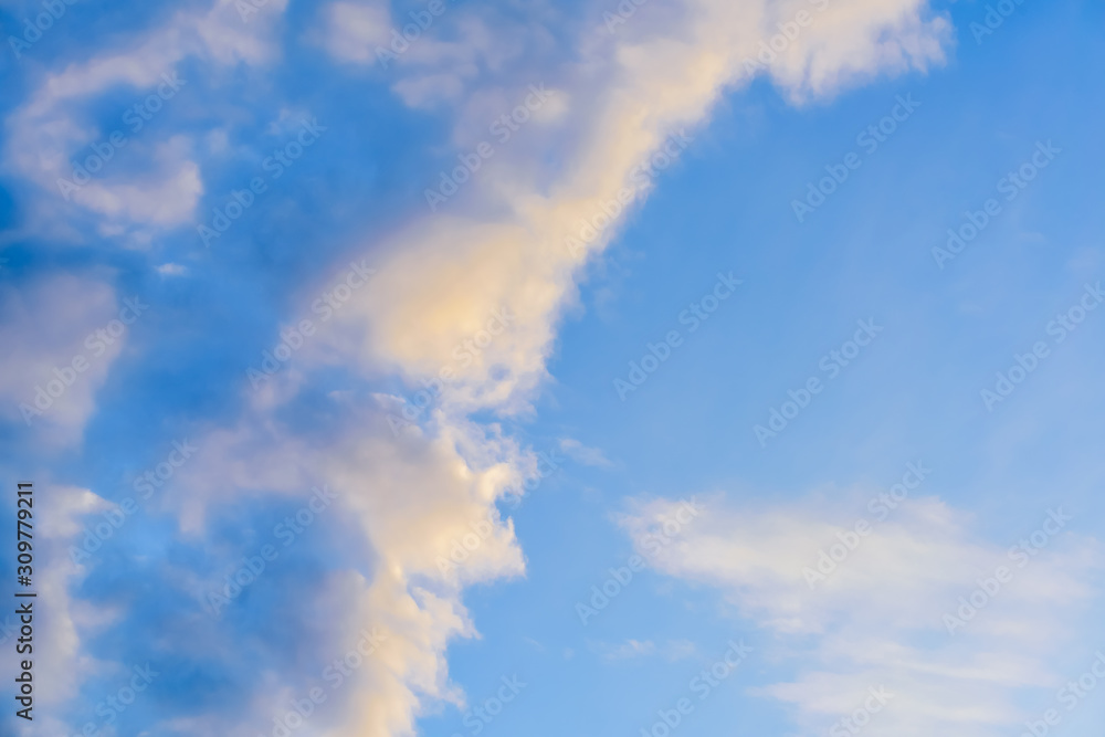 Beautiful puffy clouds at sunset isolated against pastel blue and pink skies Beautiful puffy clouds at sunset isolated against pastel blue and pink skies