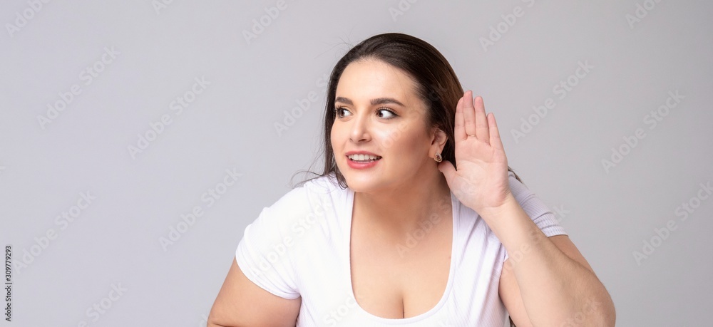 Shocked Plus Size Model with long hair posing in studio. Listen Shocked Plus Size Model with long hair posing in studio. Listen