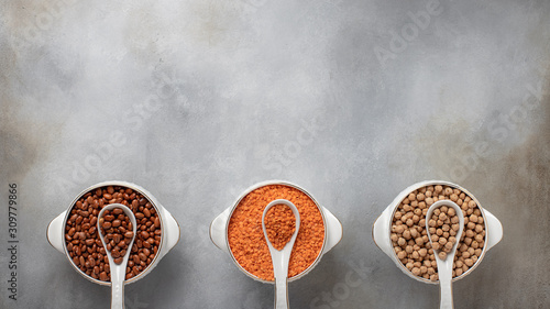 set of 3 cereals: beans, lentils, chickpeas. healthy eating. banner, place for text. gray concrete background, top view