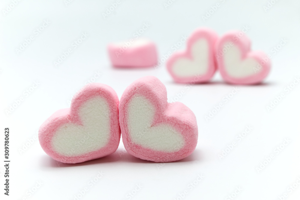 Obraz premium Pink sweet heart shape marshmallow on white background.