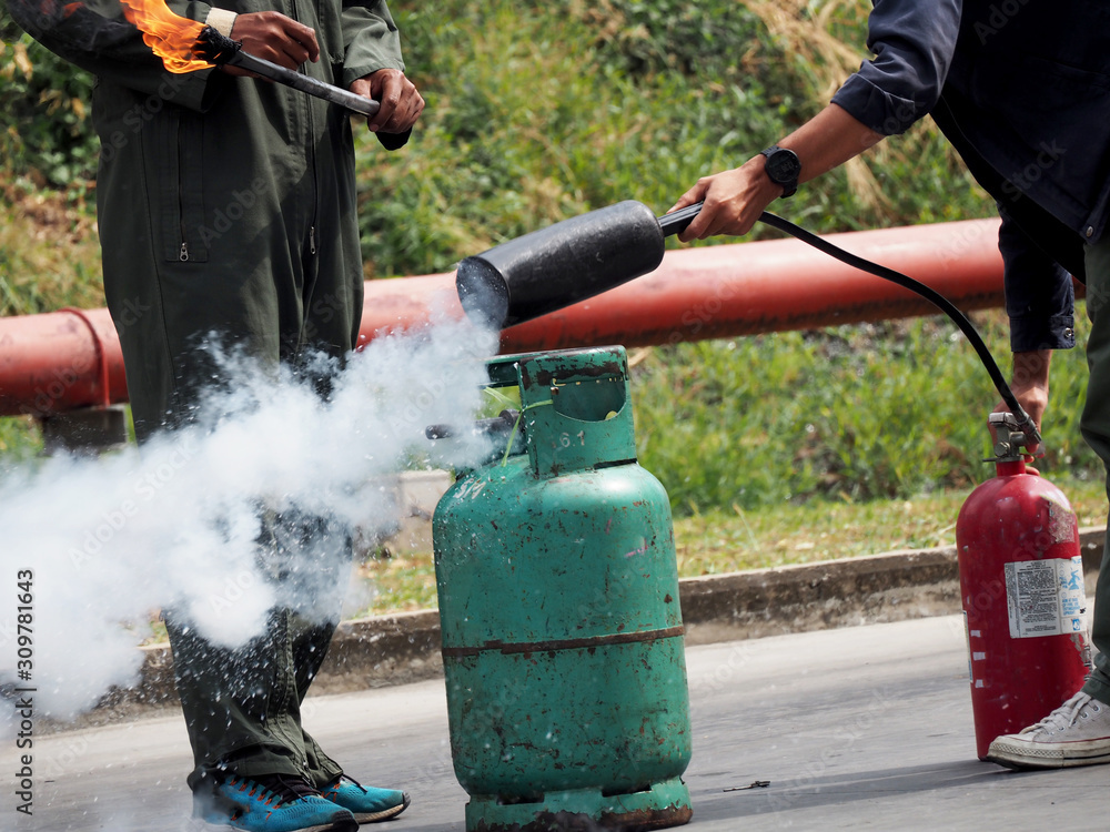 Fototapeta premium firefighter training., fireman using water and extinguisher to fighting with fire flame in an emergency situation