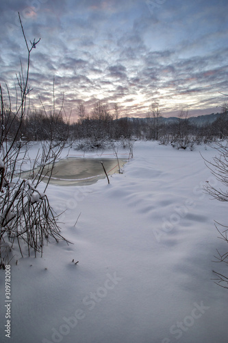 winter landscape with an ice hole in the lake