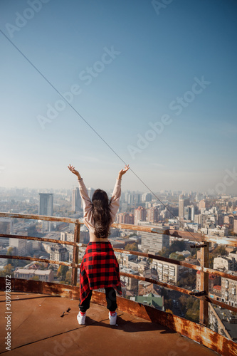 Lady with hands up staying on roof